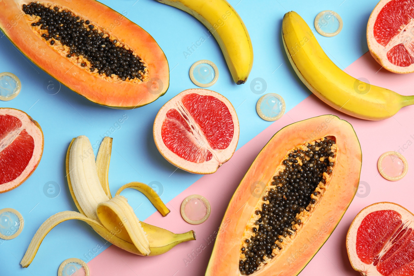 Photo of Flat lay composition with condoms and exotic fruits on color background. Erotic concept