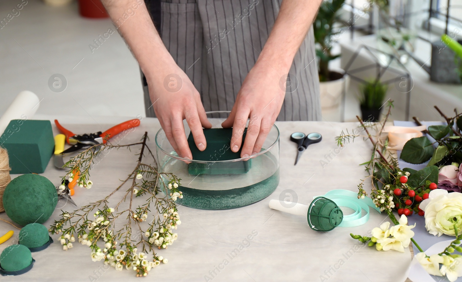 Photo of Male florist creating floral composition at workplace