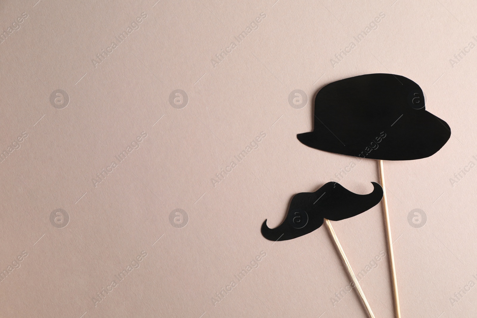 Photo of Fake paper mustache and hat with sticks on grey background, flat lay. Space for text