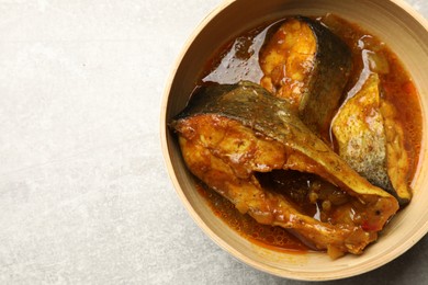 Photo of Tasty fish curry on light grey table, top view. Space for text. Indian cuisine