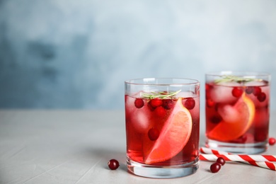 Tasty refreshing cranberry cocktail on grey table. Space for text