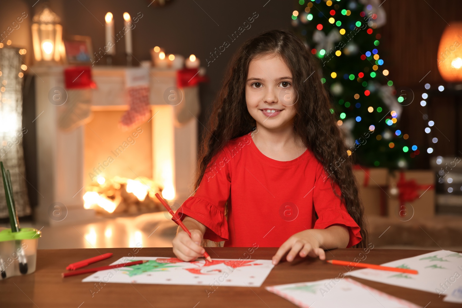 Photo of Little child drawing picture at home. Christmas celebration