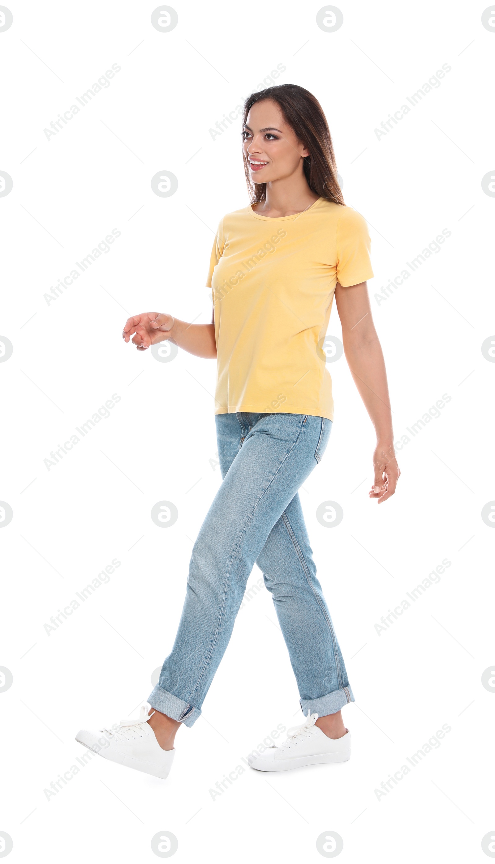 Photo of Beautiful young woman in casual outfit walking on white background