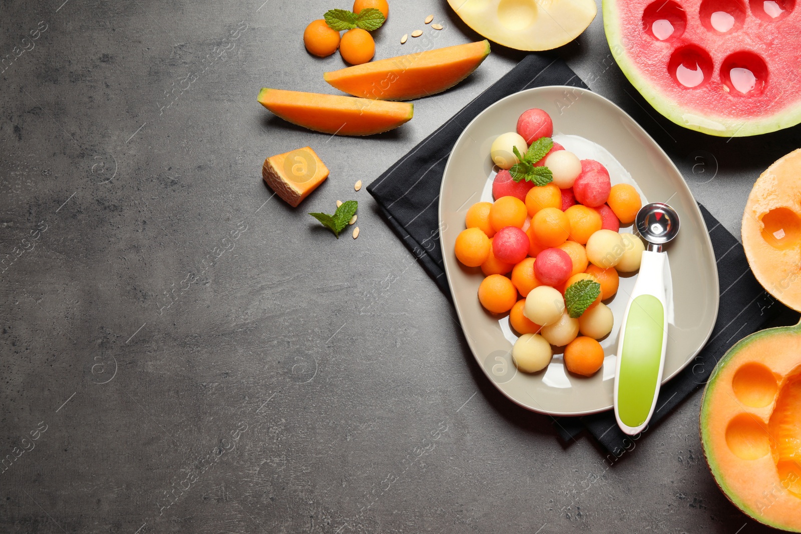 Photo of Flat lay composition with melon and watermelon balls on grey table, space for text