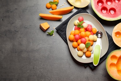 Flat lay composition with melon and watermelon balls on grey table, space for text