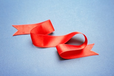 Photo of Simple red ribbon on color background. Festive decoration