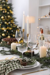 Christmas table setting with festive decor and dishware in room