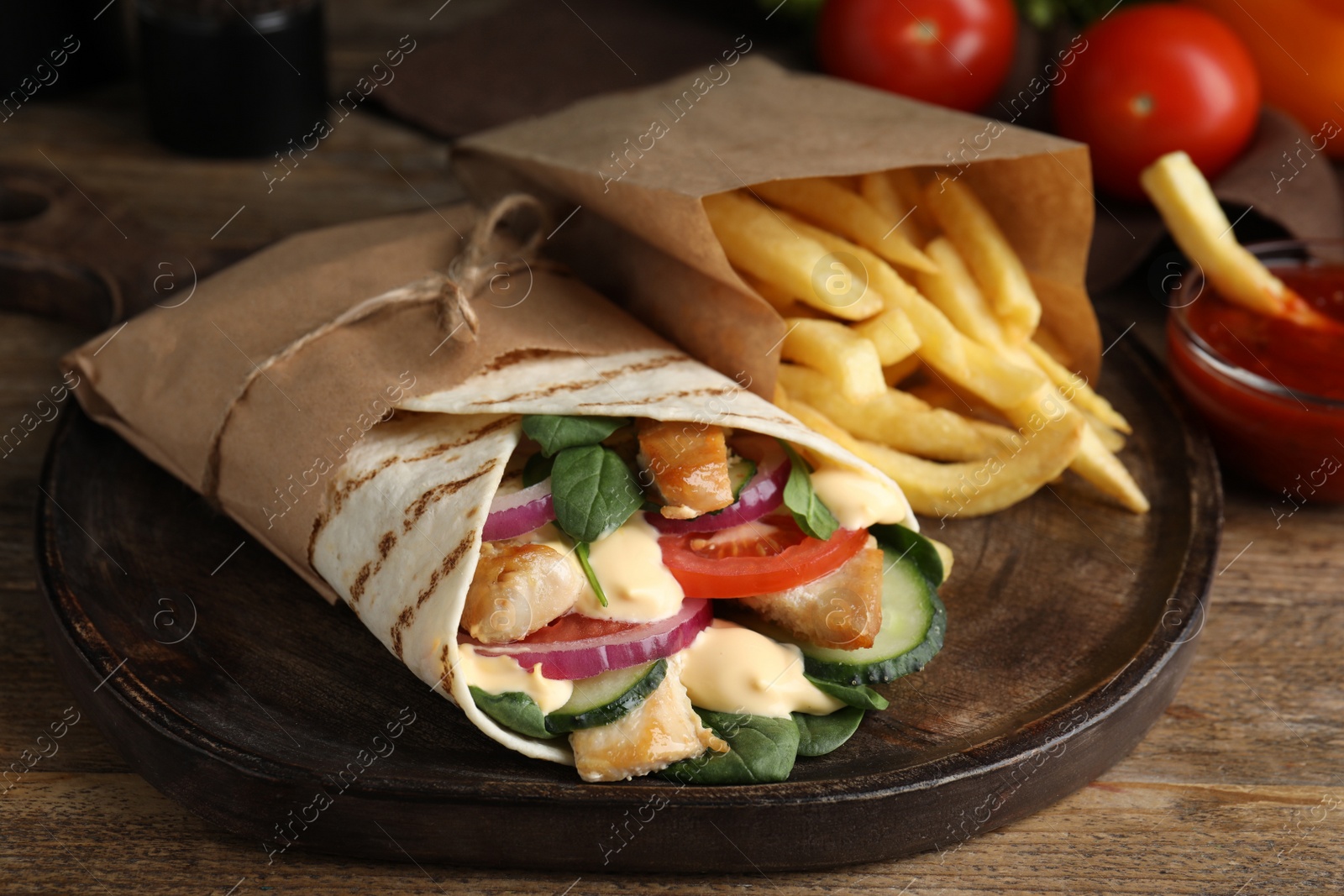 Photo of Delicious chicken shawarma and French fries on wooden table, closeup