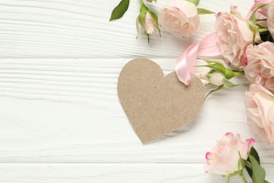 Photo of Happy Mother's Day. Beautiful flowers with blank heart shaped card on white wooden table, flat lay. Space for text