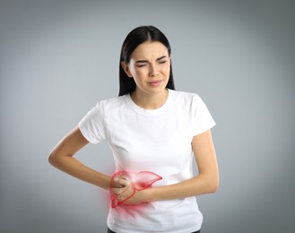 Image of Woman suffering from liver pain on grey background