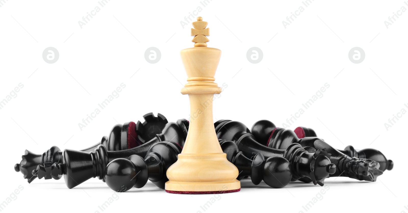 Photo of King among fallen chess pieces on white background