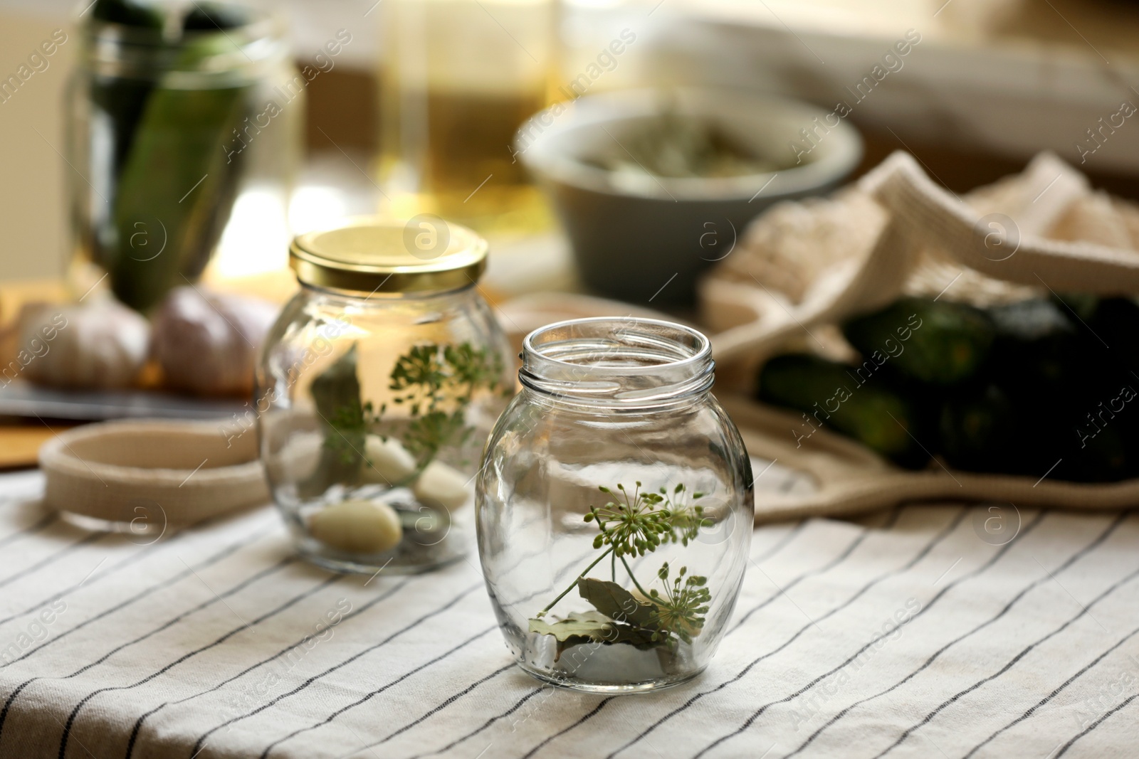 Photo of Empty glass jars and ingredients prepared for canning on table