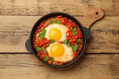 Photo of Delicious Shakshuka on wooden table, top view