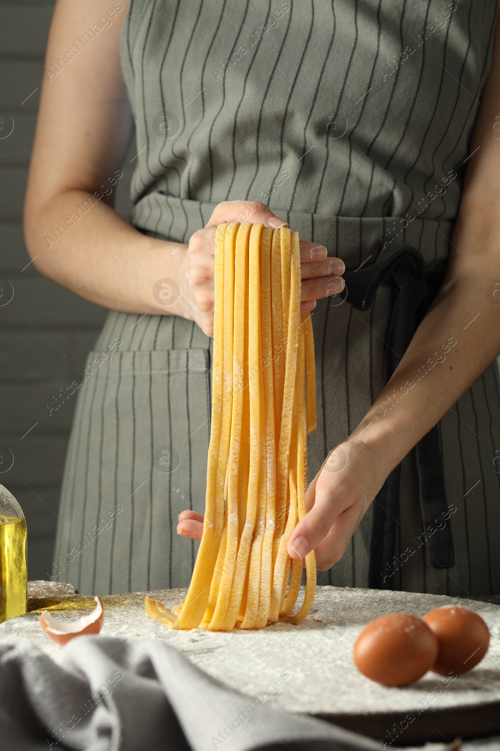 Photo of Woman making homemade pasta at table, closeup