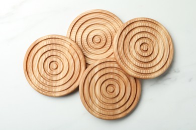 Photo of Stylish wooden cup coasters on white marble table, top view