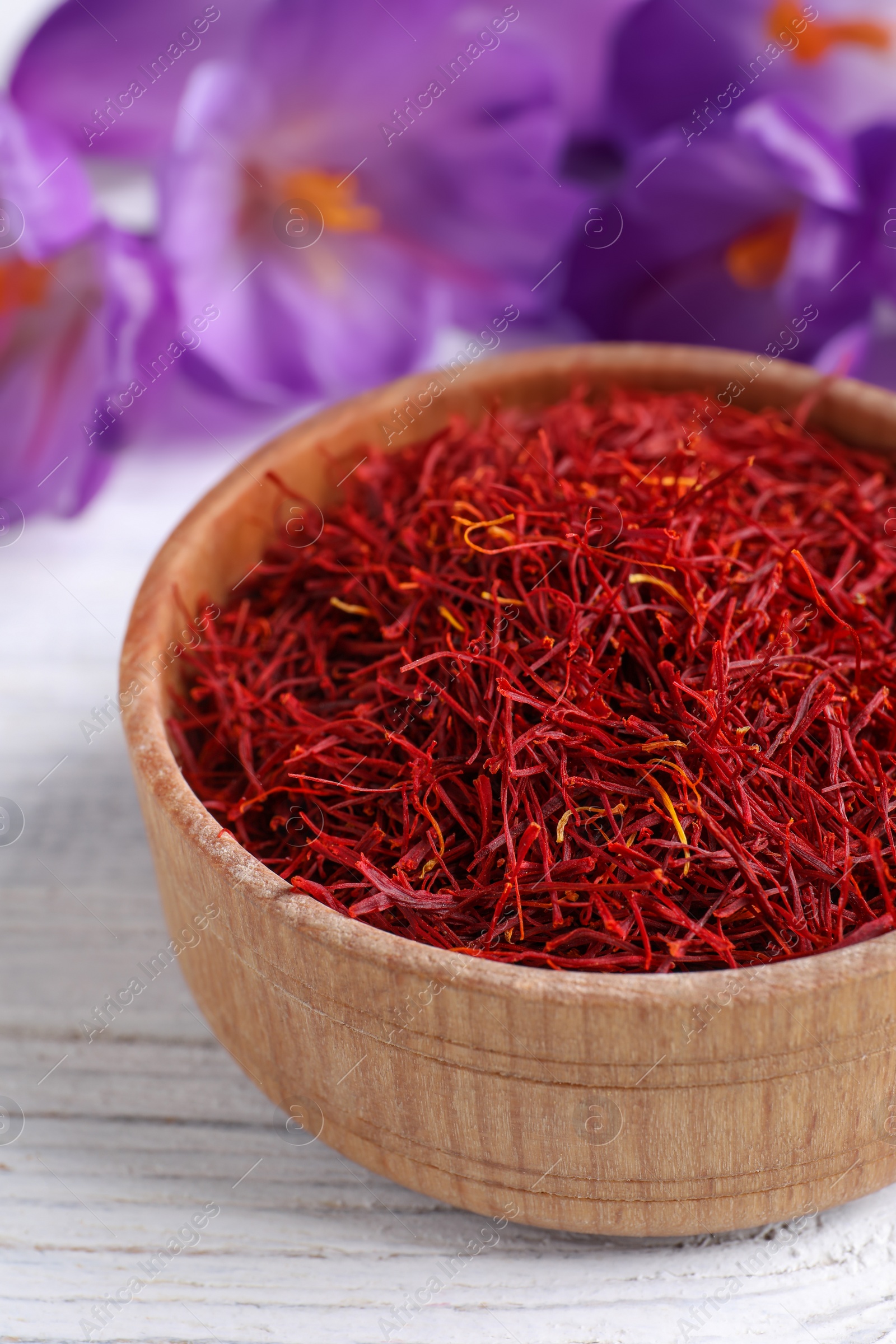 Photo of Dried saffron and crocus flowers on white wooden table, closeup