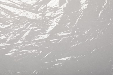 Photo of Transparent plastic stretch wrap film as background, top view