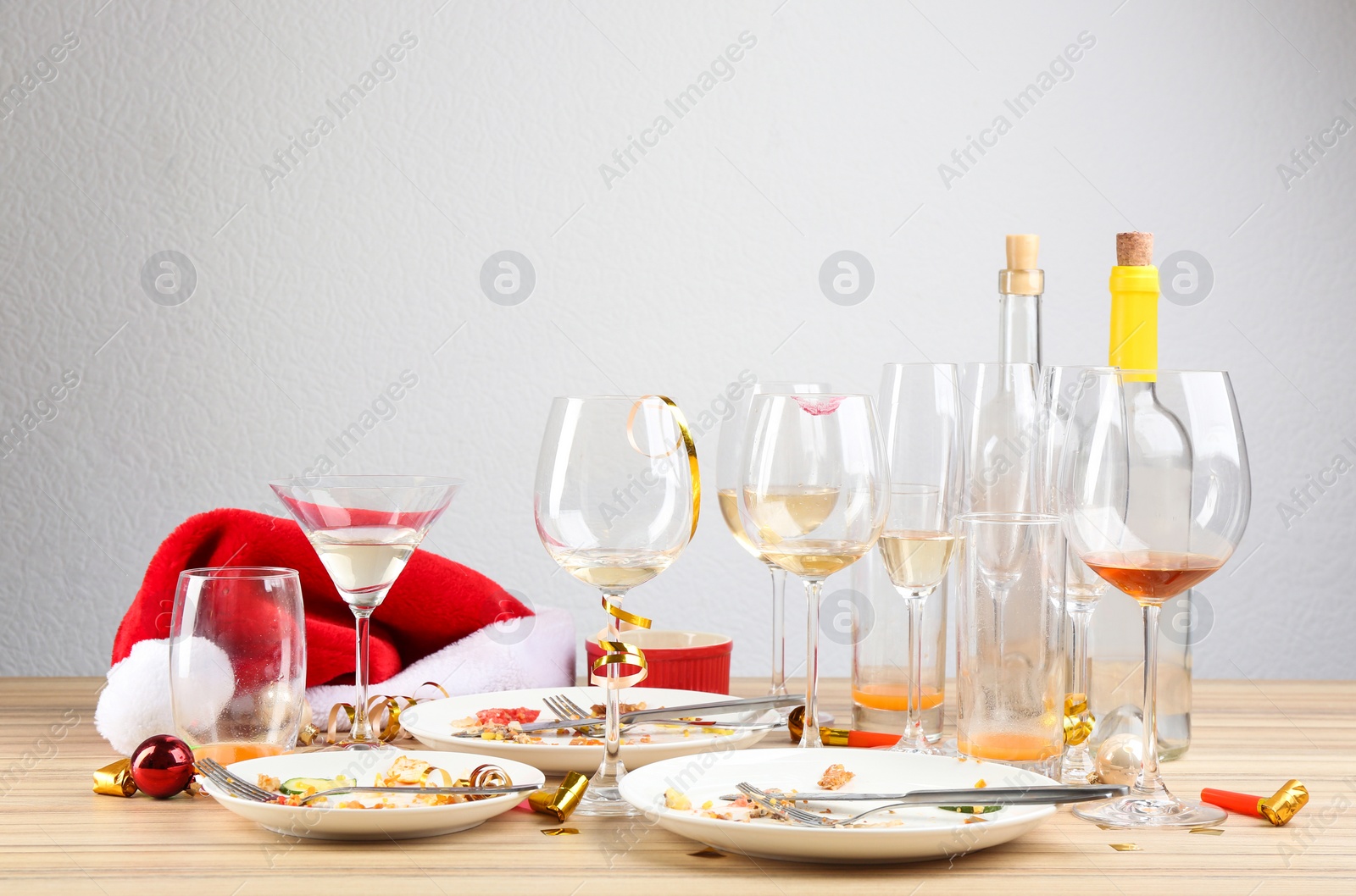 Photo of Dirty dishes with leftovers on wooden table after party