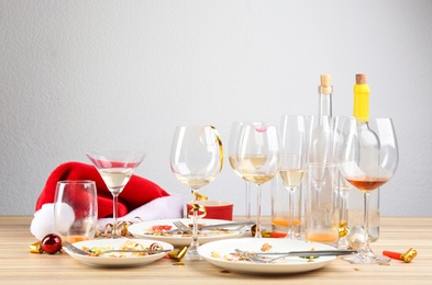 Photo of Dirty dishes with leftovers on wooden table after party