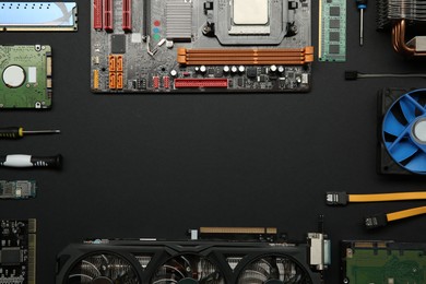 Photo of Frame of graphics card and other computer hardware on black background, flat lay. Space for text