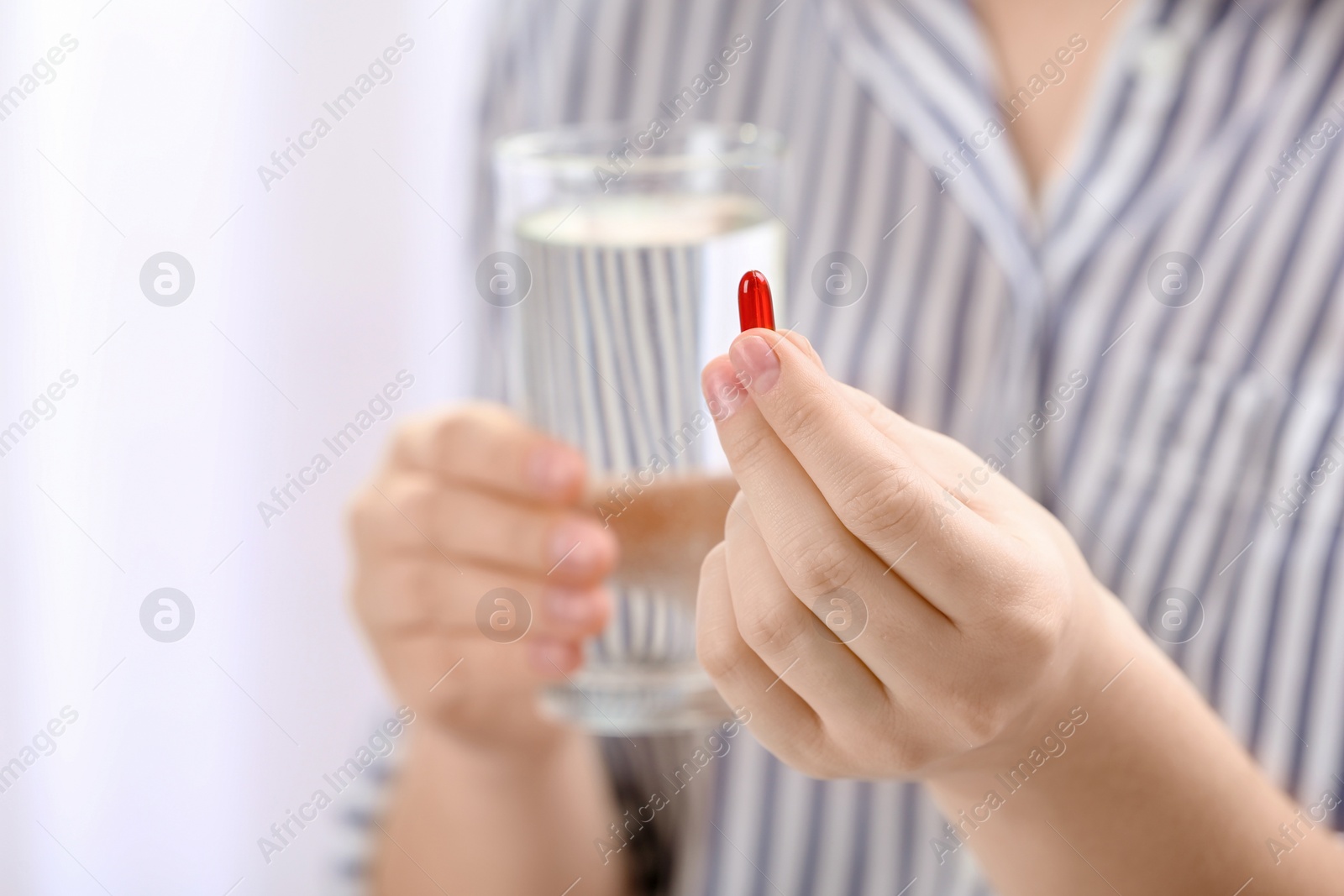 Photo of Young woman with pill and glass of water, closeup