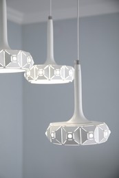 Photo of Stylish white pendant lamp in light room