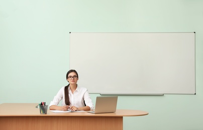 Photo of Female teacher at her desk in classroom