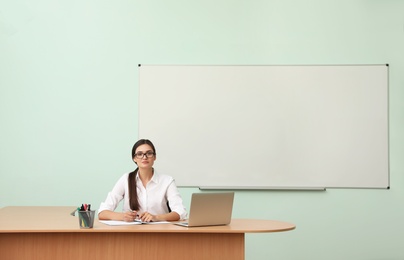 Female teacher at her desk in classroom