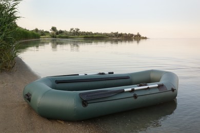 Photo of Inflatable rubber fishing boat on sandy beach near river