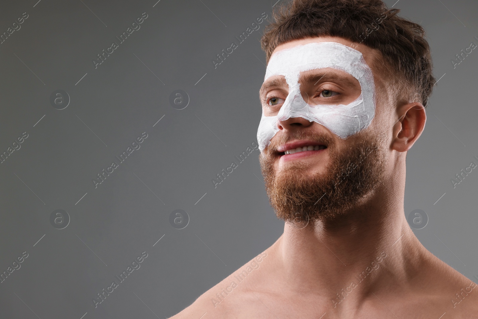 Photo of Handsome man with facial mask on his face against grey background, space for text