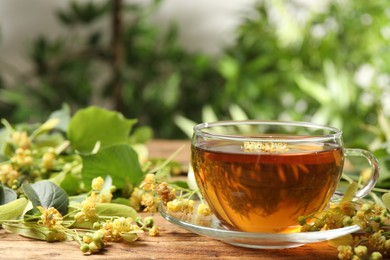 Cup of tea and linden blossom on wooden table