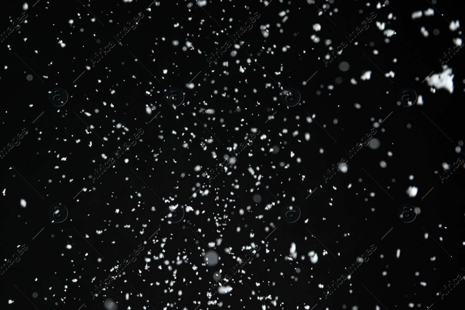 Photo of White snow falling down on black background