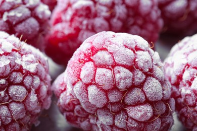 Many frozen ripe raspberries on table, closeup