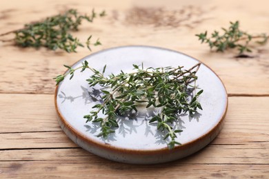 Board with fresh thyme on wooden table