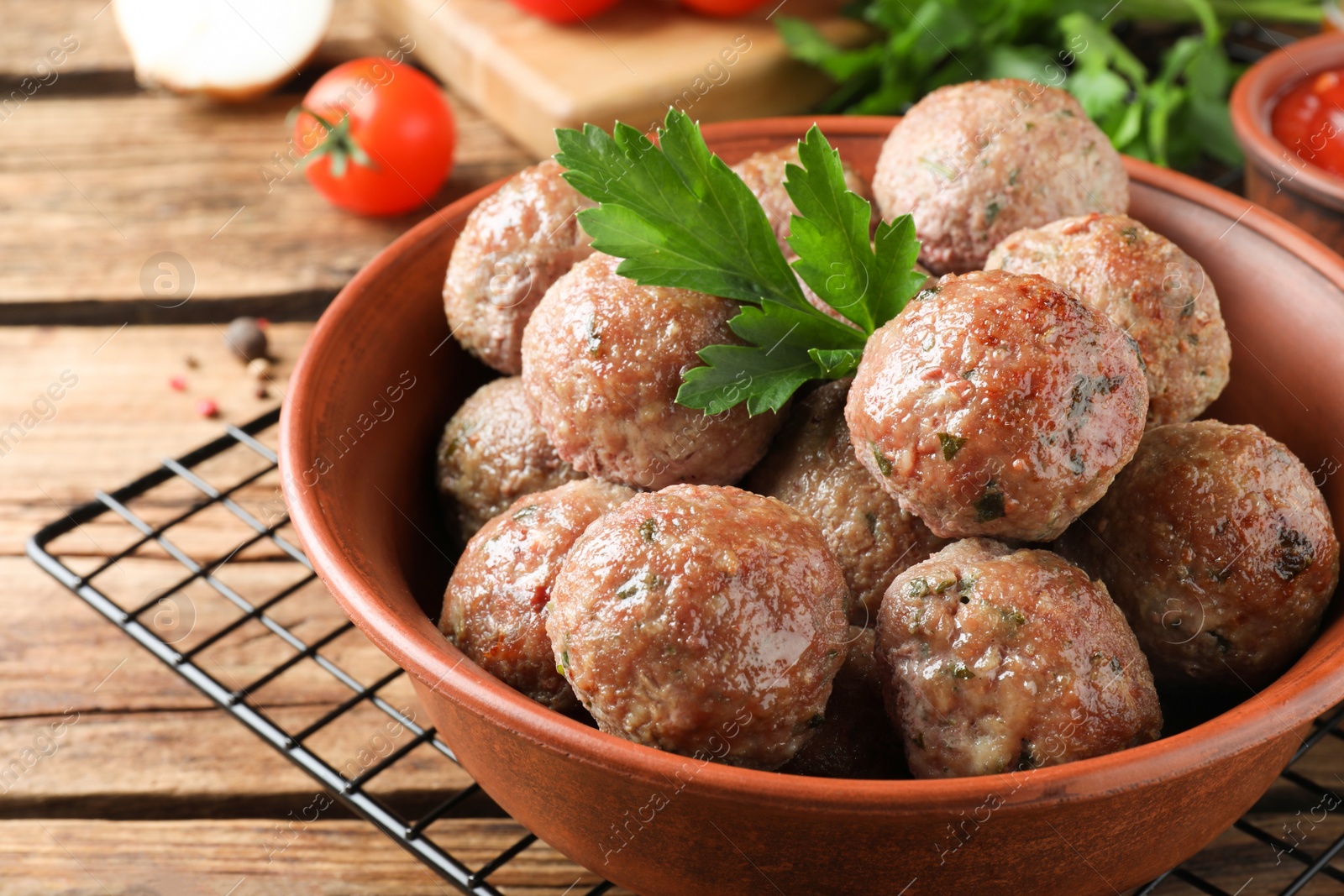 Photo of Tasty cooked meatballs with parsley on wooden table, closeup