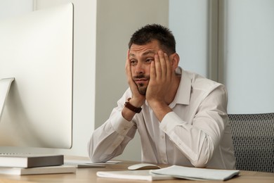 Sleep deprived man at workplace in office