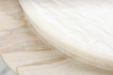Photo of Stack of dry rice paper on board, closeup