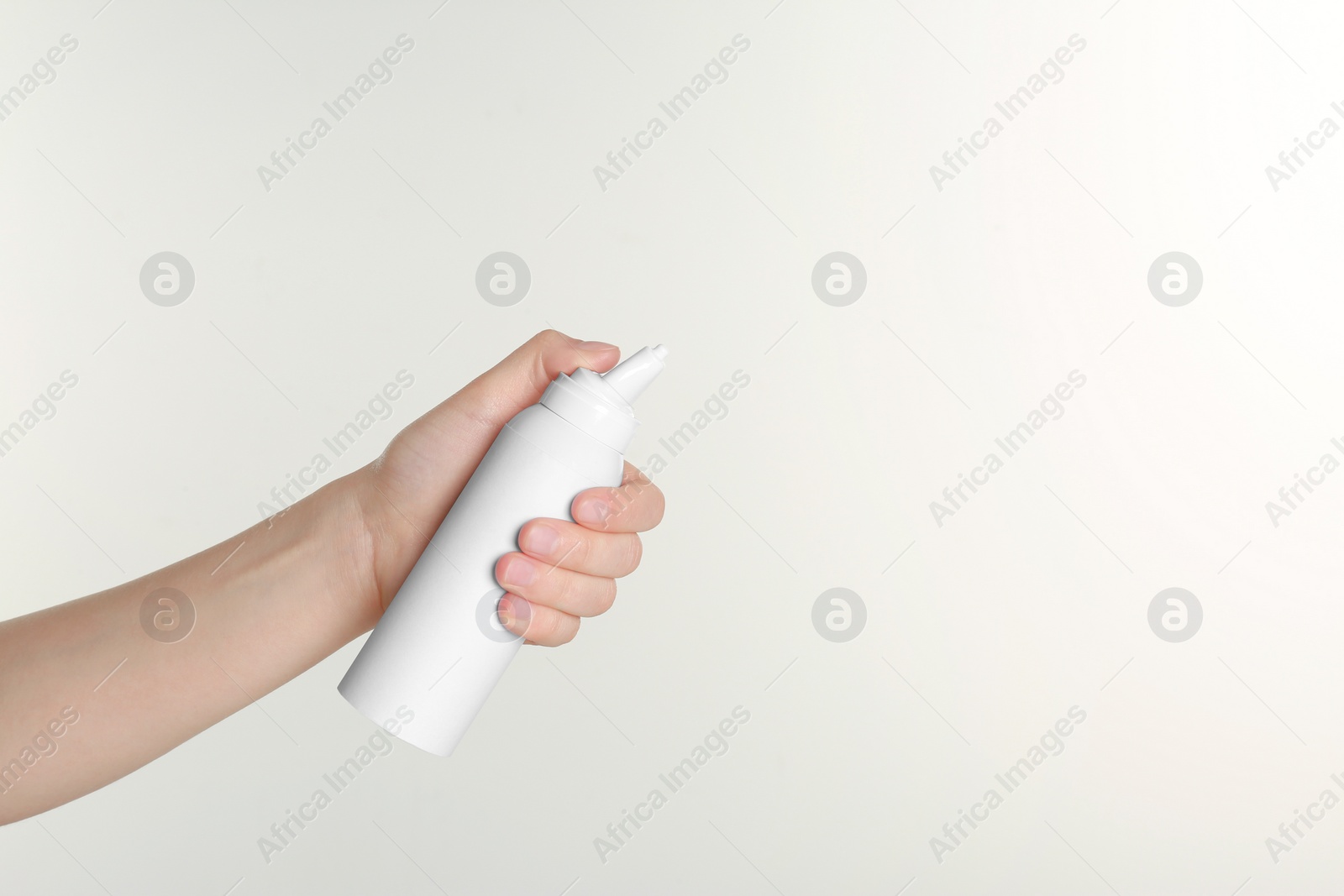 Photo of Woman holding nasal spray on white background, closeup. Space for text