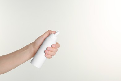 Photo of Woman holding nasal spray on white background, closeup. Space for text