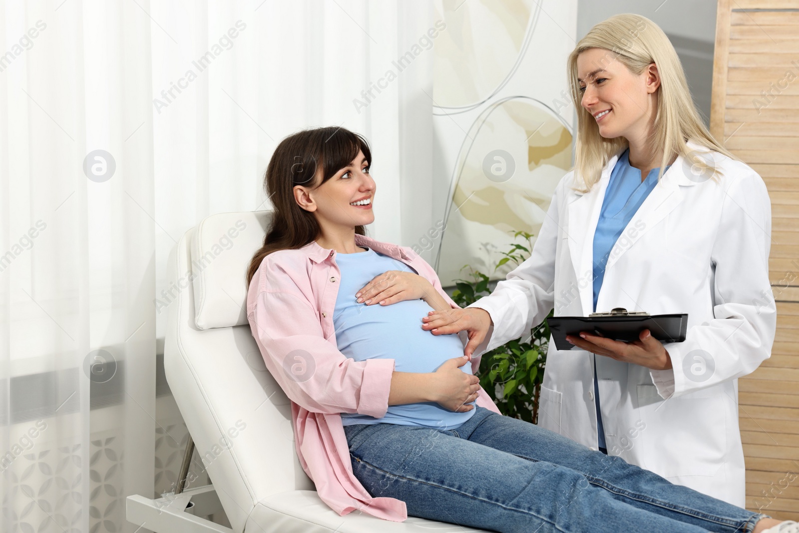 Photo of Happy pregnant woman having doctor appointment in hospital