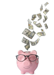 Dollars falling into pink piggy bank on white background 