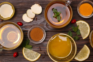 Photo of Flat lay composition of tea with honey and ingredients on wooden table