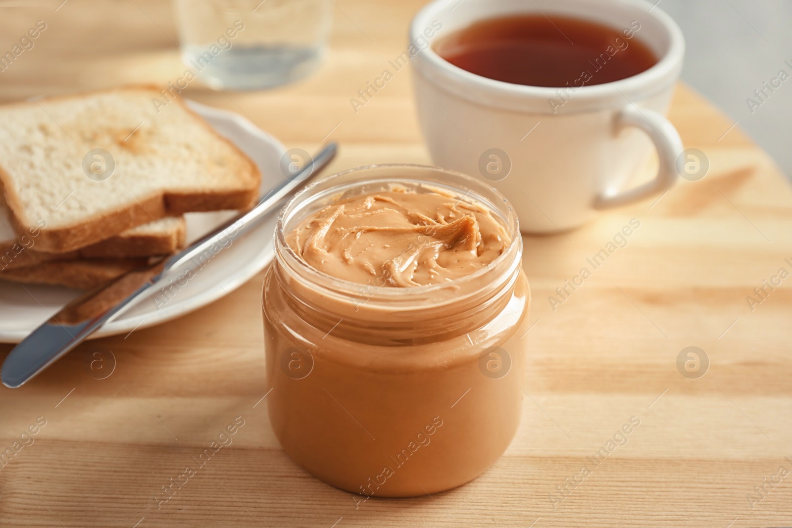 Photo of Jar with creamy peanut butter on table