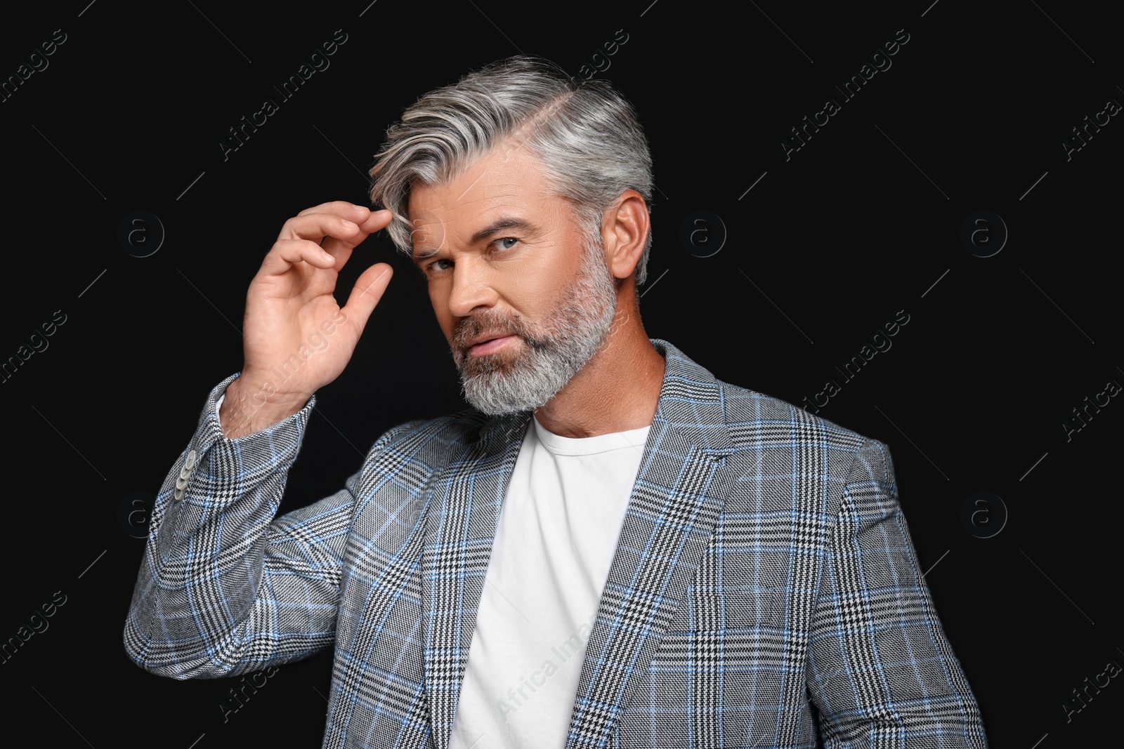 Photo of Portrait of confident man with beautiful hairstyle on black background