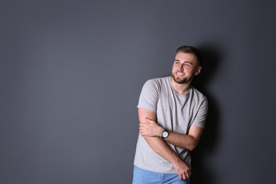 Portrait of handsome happy man on grey background, space for text