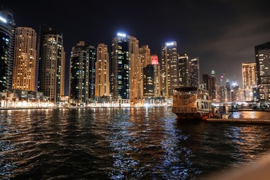 DUBAI, UNITED ARAB EMIRATES - NOVEMBER 03, 2018: Night cityscape of marina district with moored boat and illuminated buildings