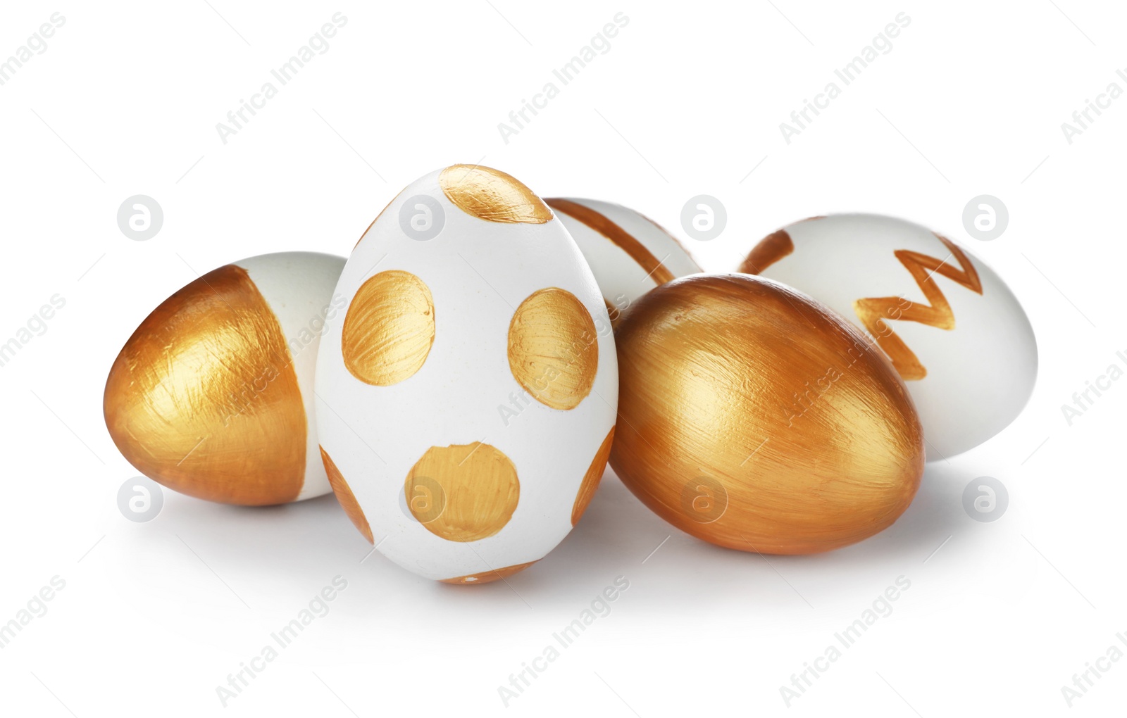 Photo of Set of traditional Easter eggs decorated with golden paint on white background