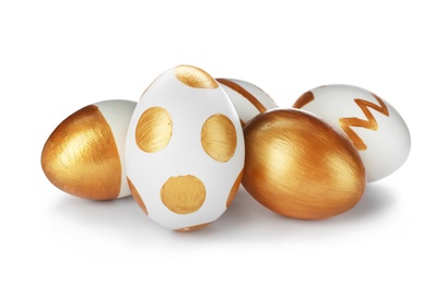 Photo of Set of traditional Easter eggs decorated with golden paint on white background