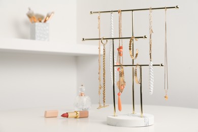 Photo of Holder with set of luxurious jewelry on white dressing table