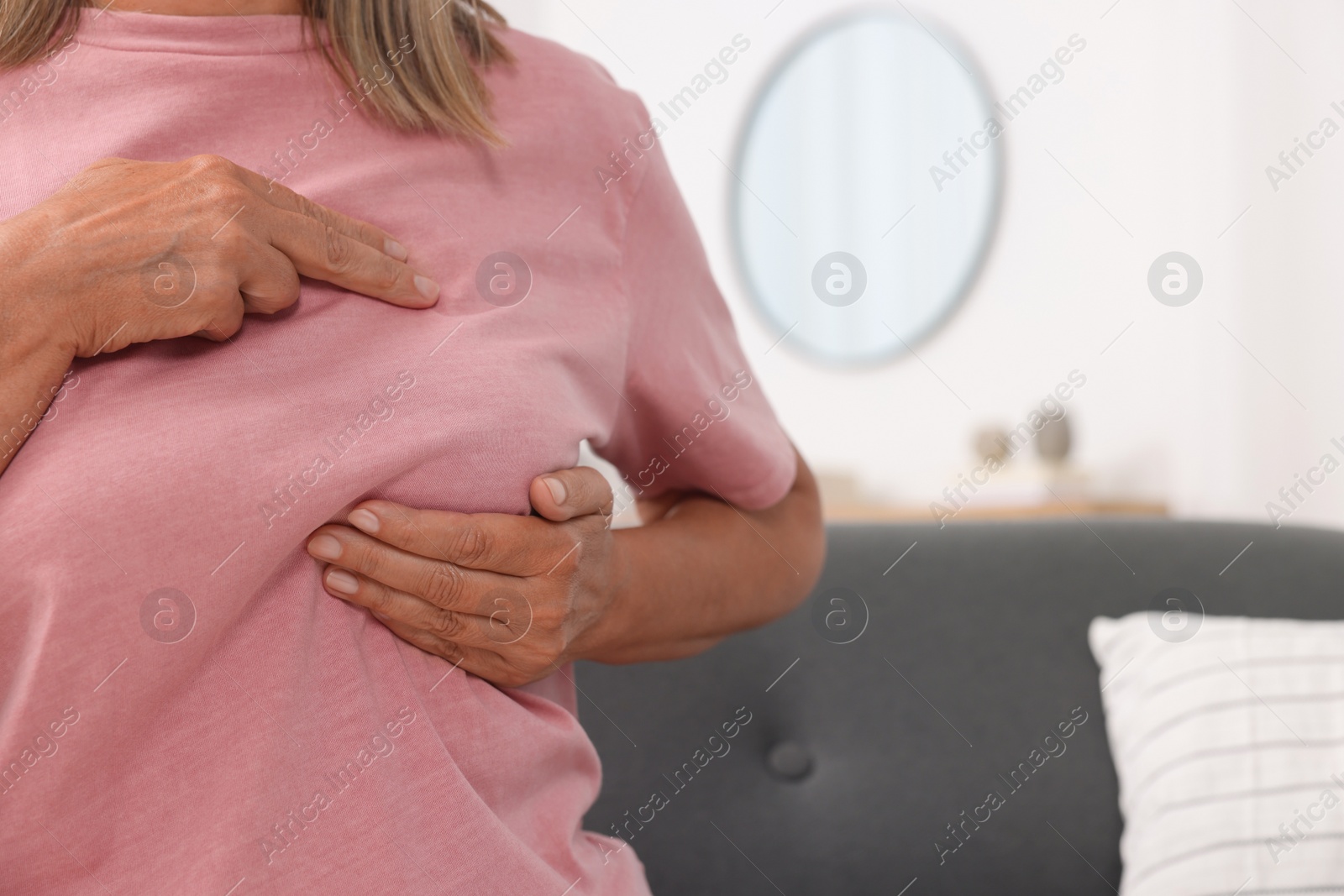 Photo of Woman doing breast self-examination at home, closeup. Space for text